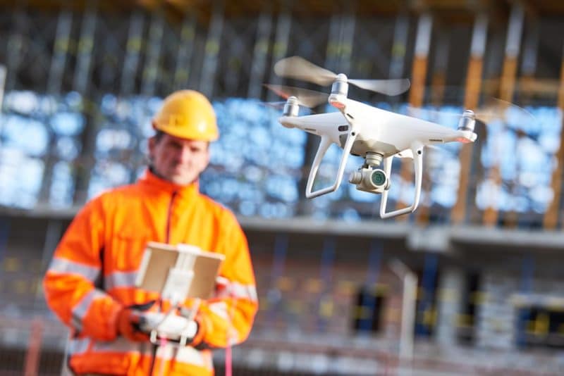 Out-of-focus drone pilot showing the drone in flight in the foreground.