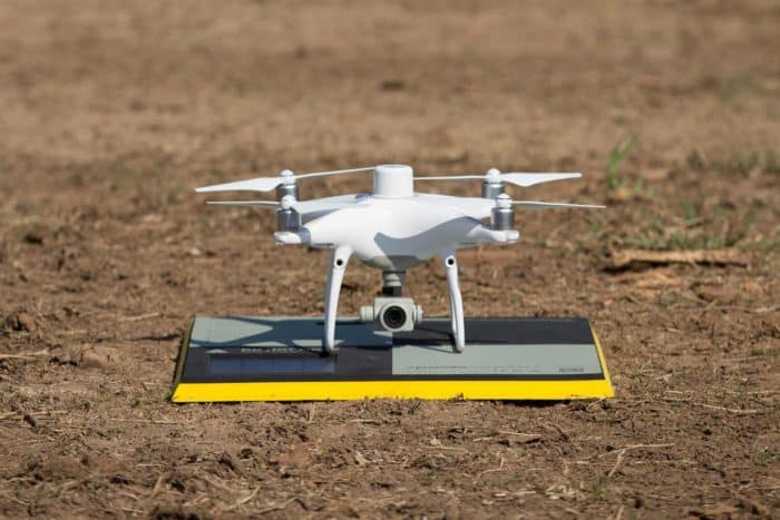 A drone sat on top of the AeroPoint on the ground.