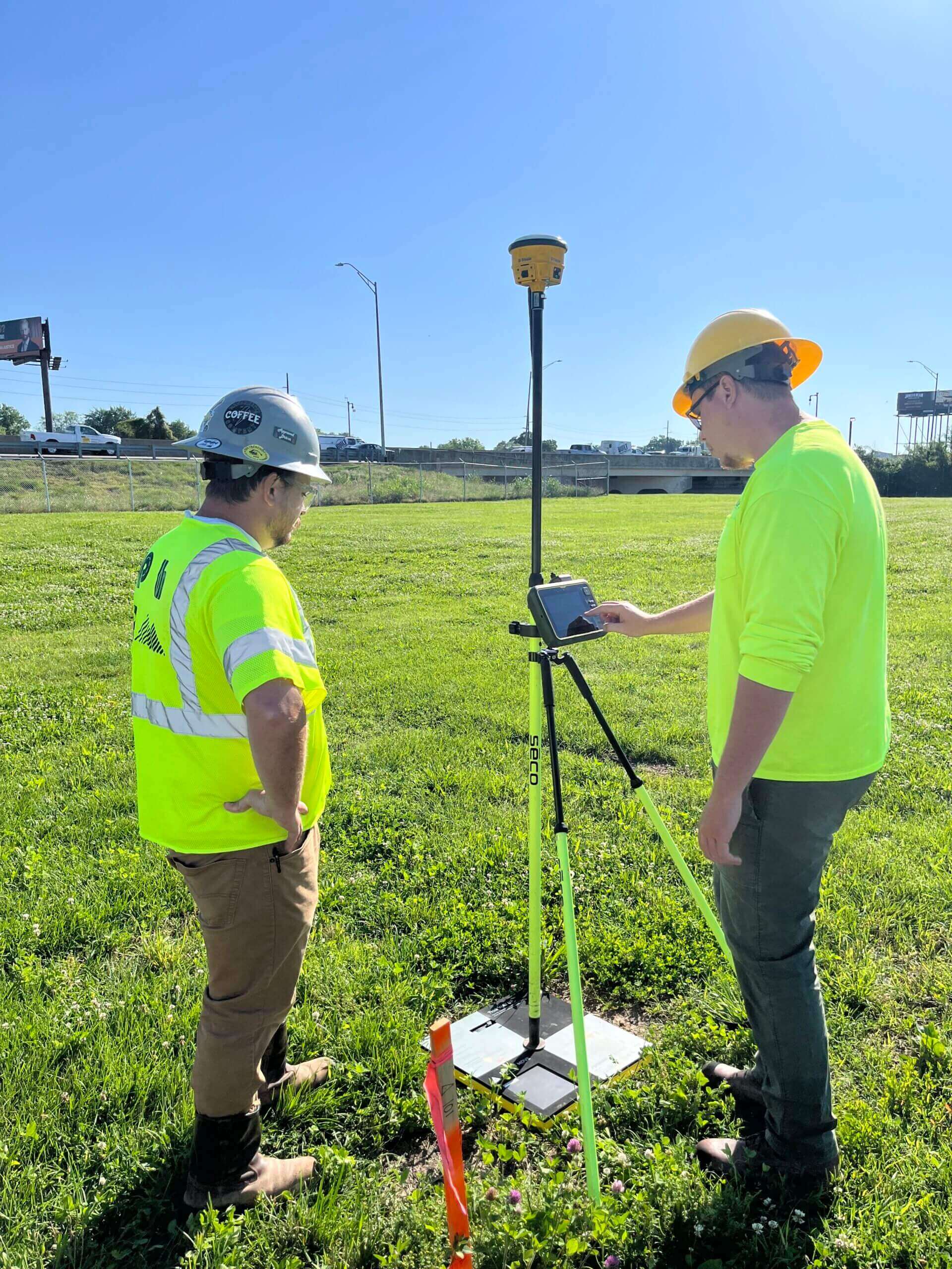two workers holding a GIS prover