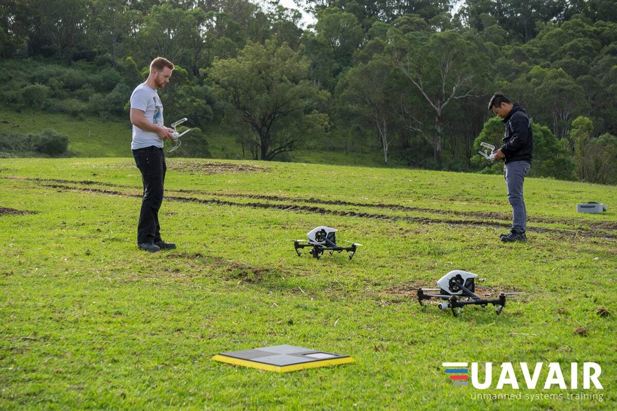 Two drone pilots in a field ready to start a flight. AeroPoint is in the foreground.