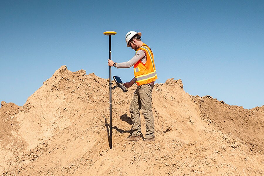 person holding a gps rover in dirt