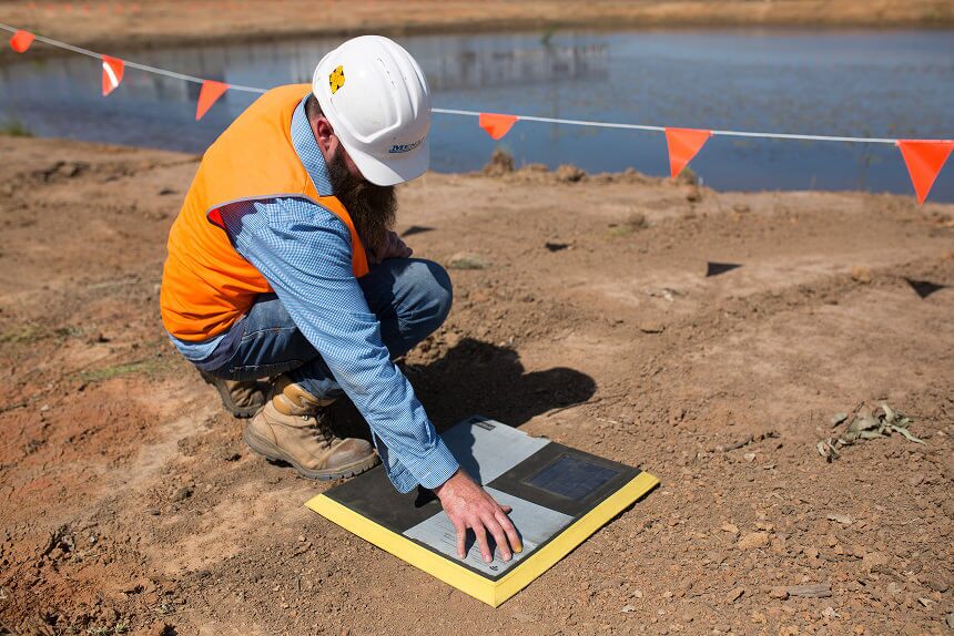man on construction site with hardhat turning on an aeropoint