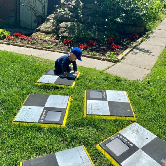 small boy playing with a handful of AeroPoints on a lawn