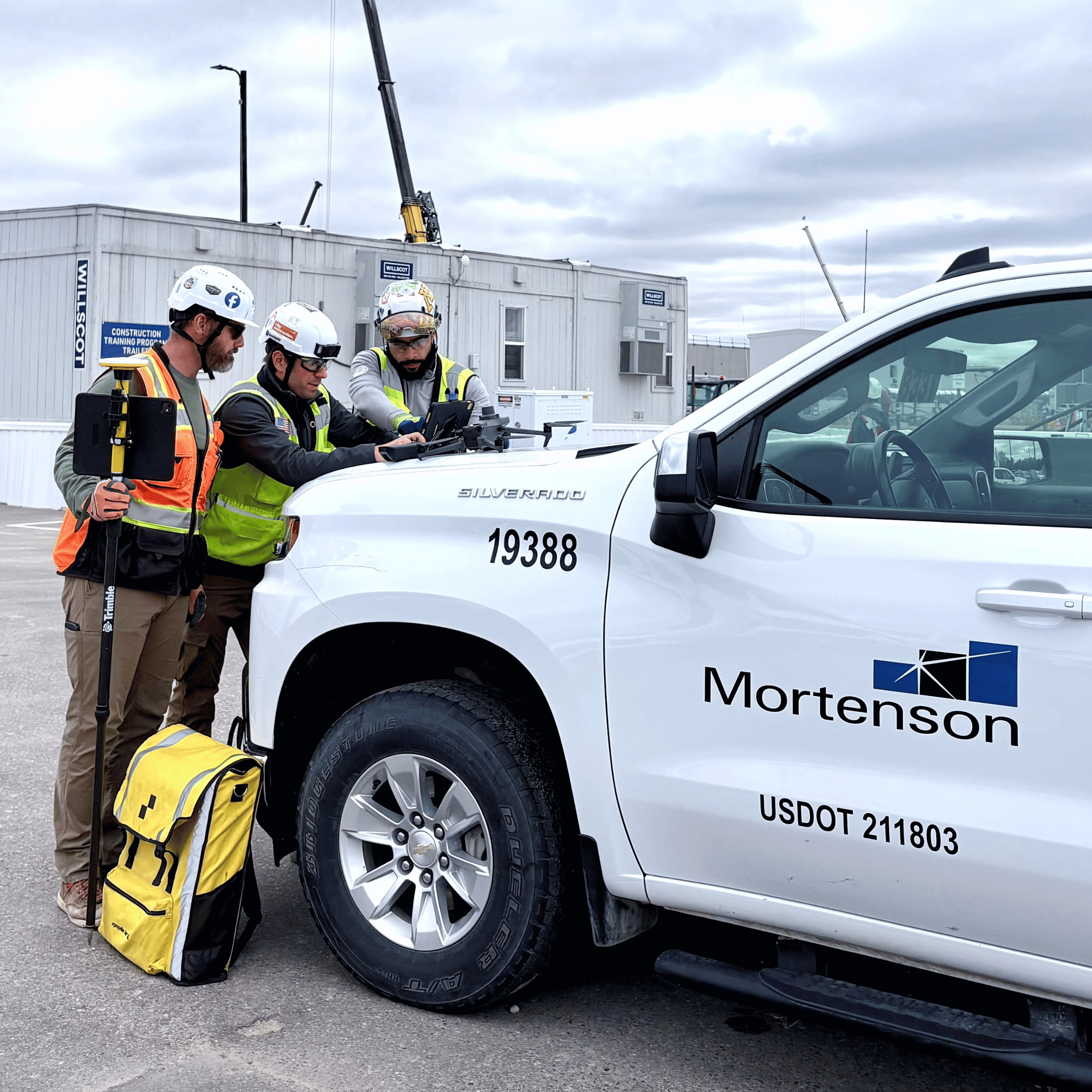 Mortenson Construction workers standing in front of a white truck