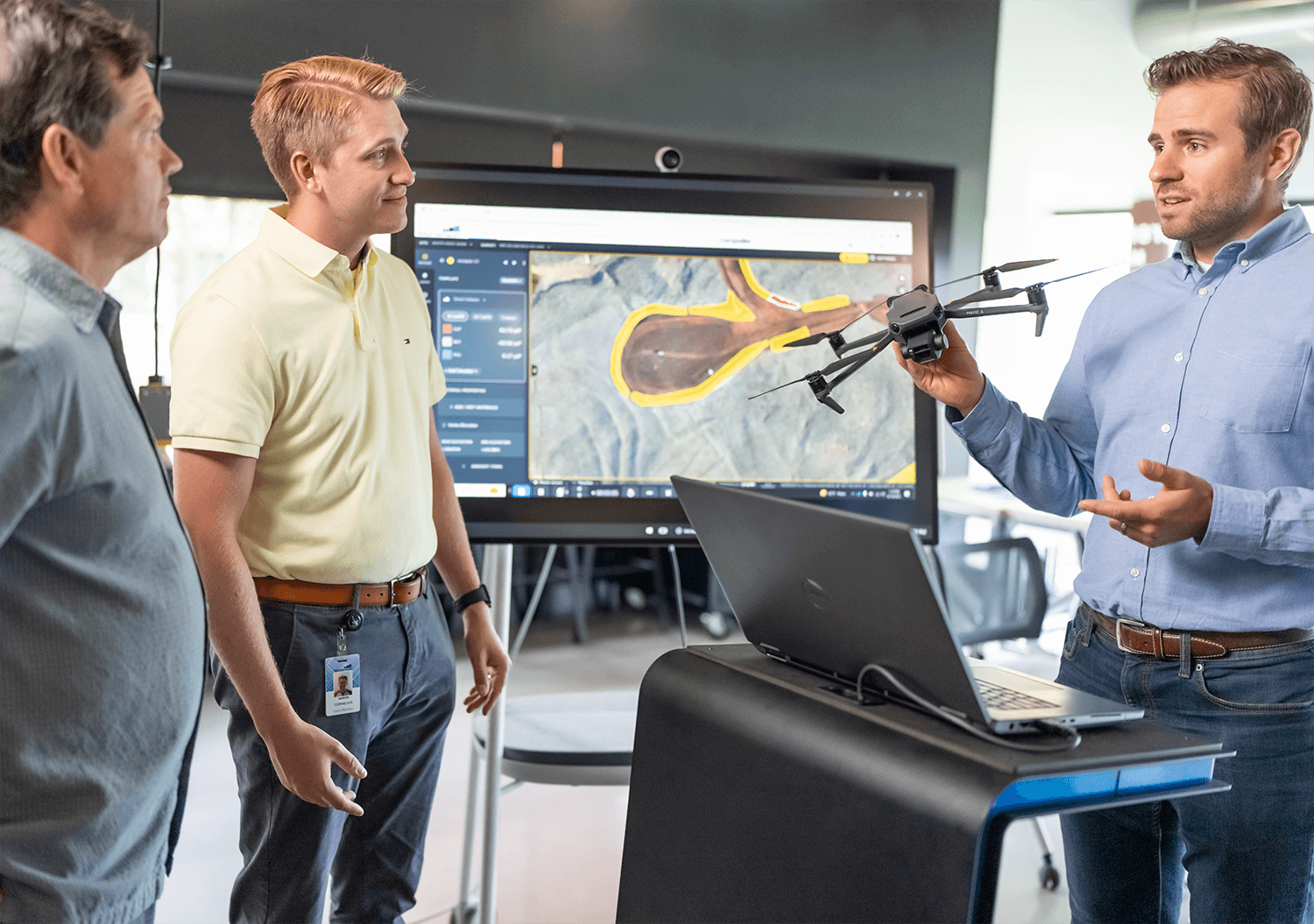 three people talking about Propeller and a drone in an office setting
