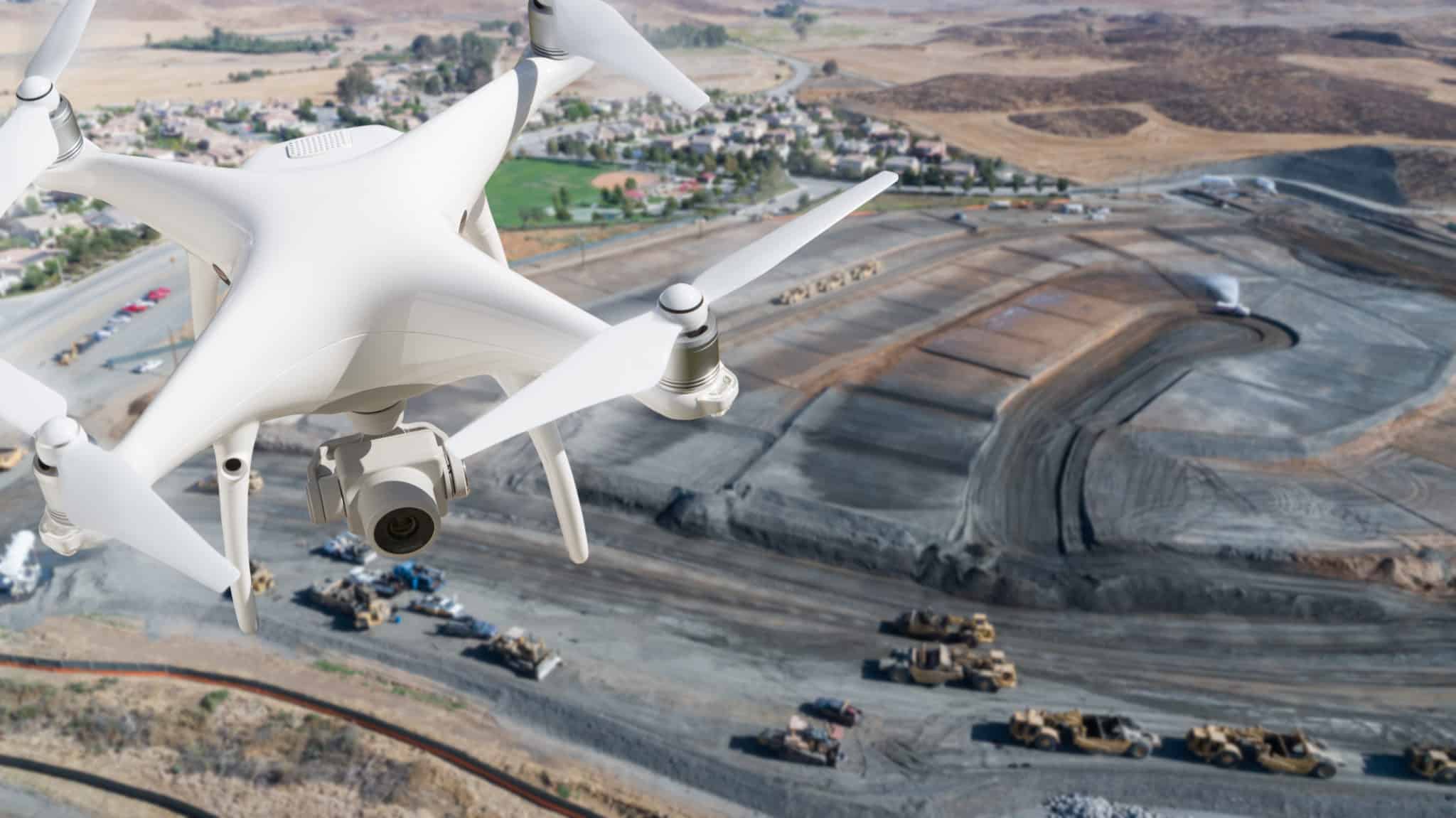 Close-up of a flying drone over a quarry site in the background.