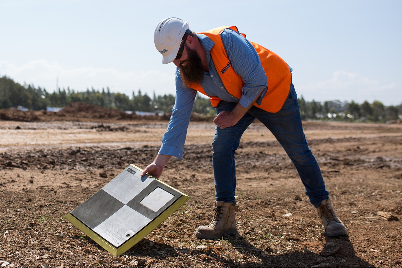 construction worker laying down an aeropoint smart ground control point