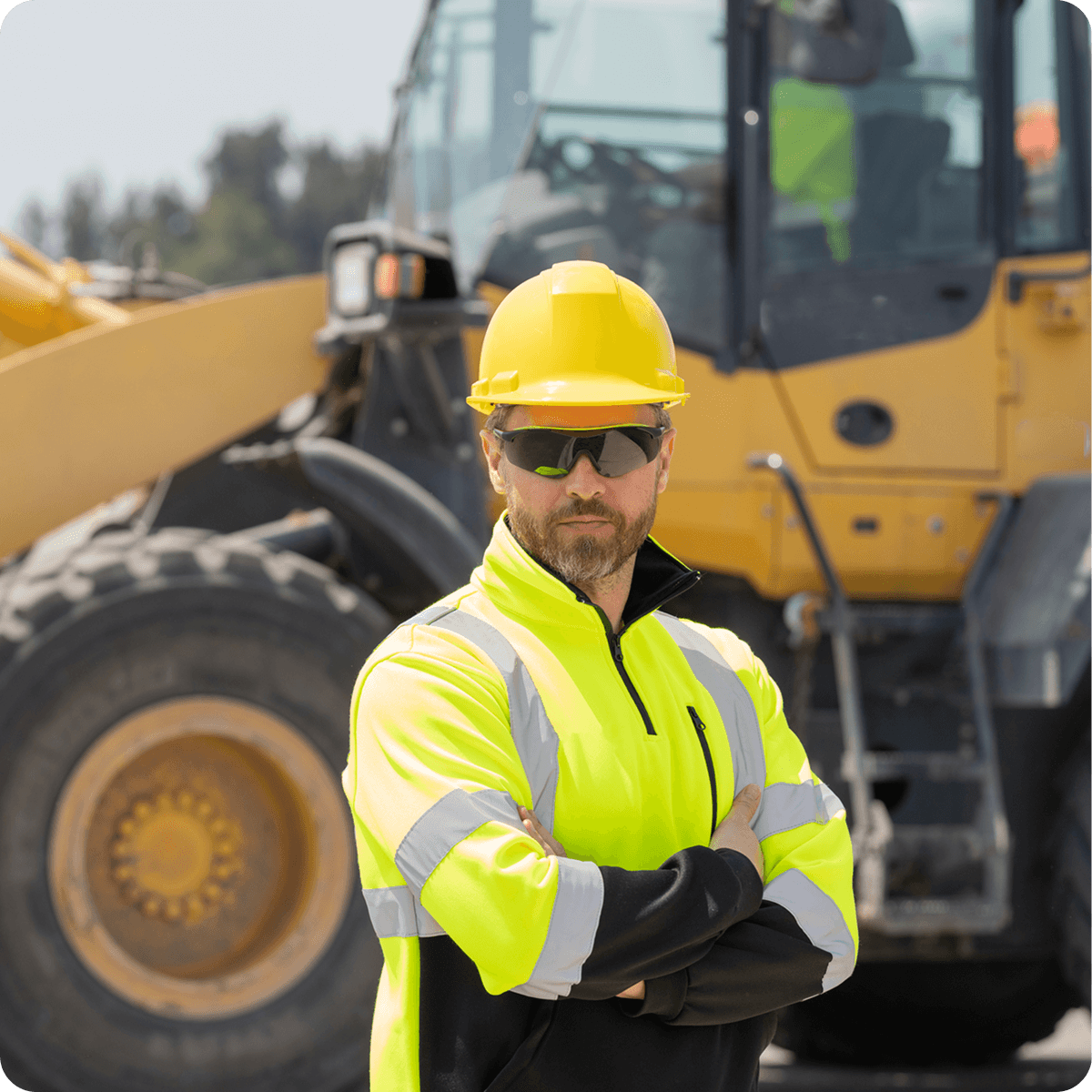 owner of a construction standing in front of a wheel loader