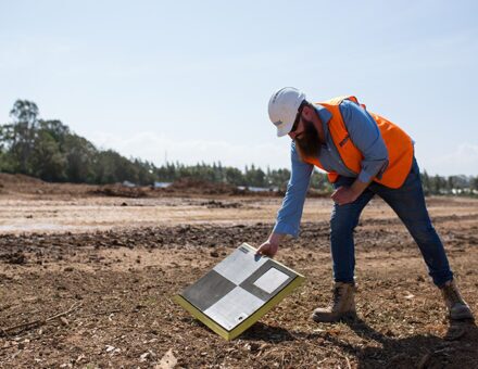 Man placing AeroPoint on the the ground of a site before drone survey