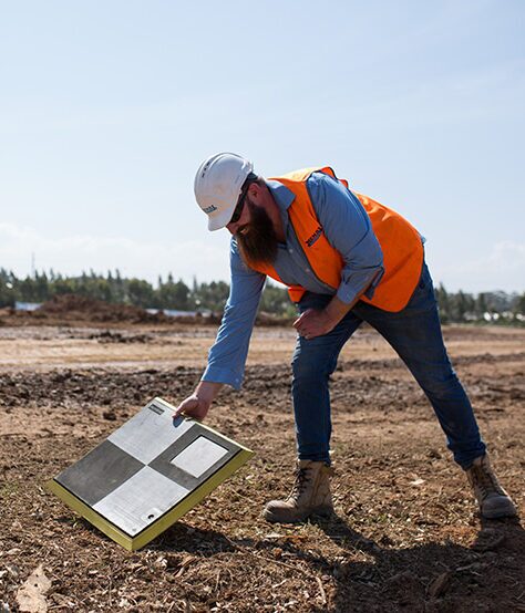Man placing AeroPoint on the the ground of a site before drone survey