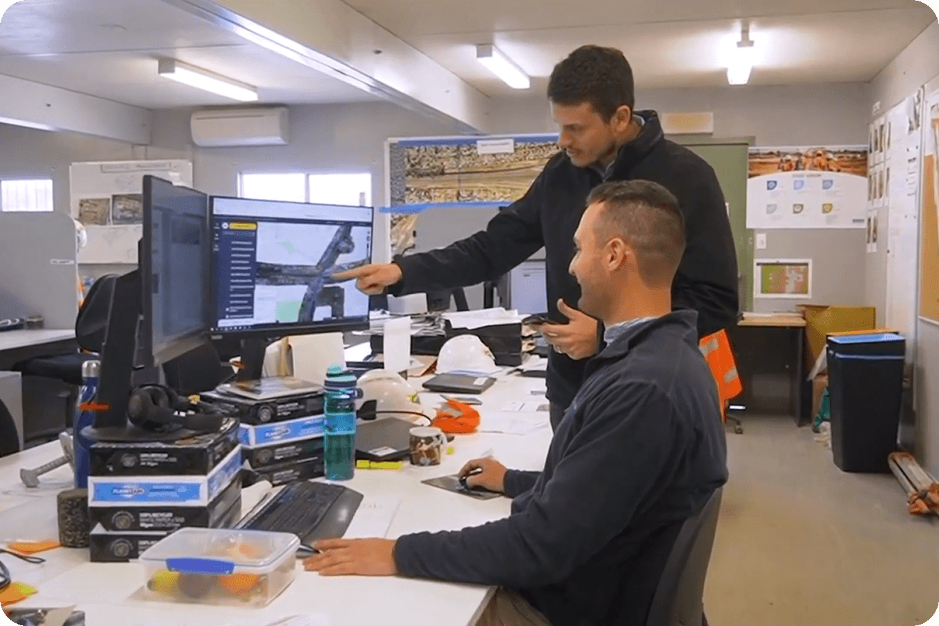 men standing by a computer reviewing their data in Propeller