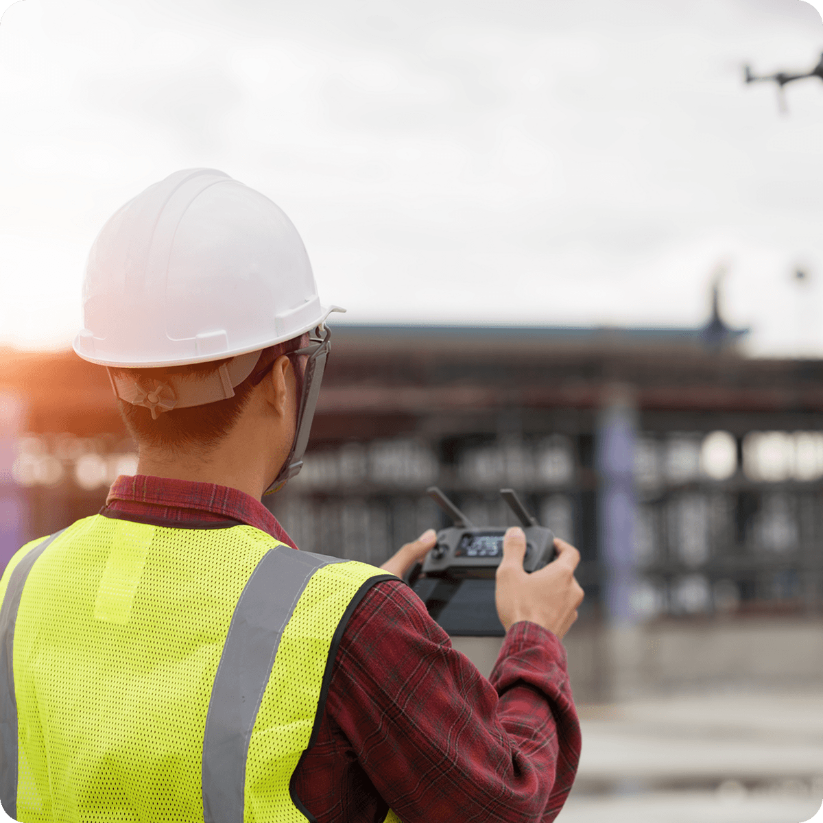 surveyor flying a drone on a construction site